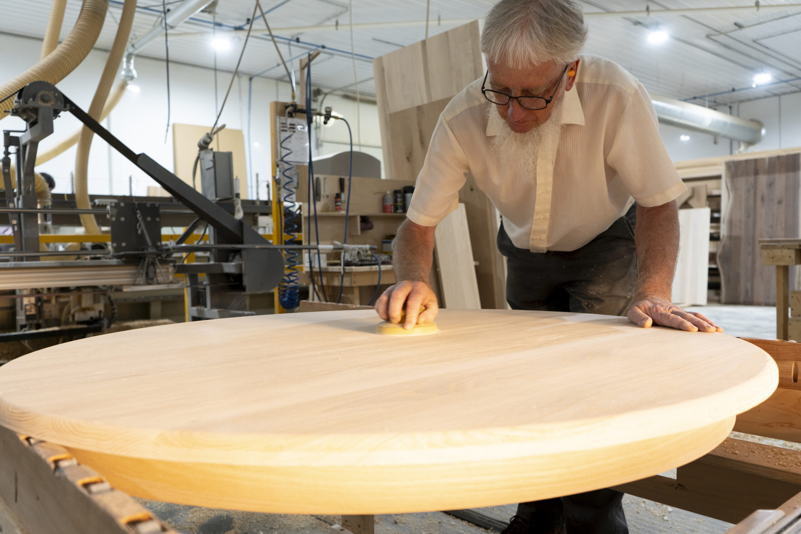 Craftsperson carefully sanding a solid wood table